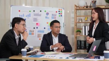 Bir grup iş adamı, finansal stratejiler hakkında konferans odasında dizüstü bilgisayarlarla beyin fırtınası ve pazarlama ve pazarlama analitik dokümanlarını tartışıyor..