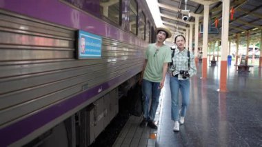 İki erkek ve kadın turist, turizm için trenle seyahat etmeye hazırlanıyor. 4K yavaş çekim videosu.