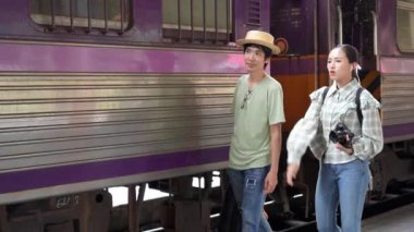 İki erkek ve kadın turist, turizm için trenle seyahat etmeye hazırlanıyor. 4K yavaş çekim videosu.