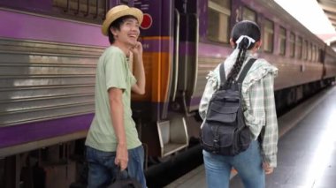İki erkek ve kadın turist, turizm için trenle seyahat etmeye hazırlanıyor. 4K yavaş çekim videosu.