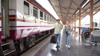İki erkek ve kadın turist, turizm için trenle seyahat etmeye hazırlanıyor. 4K yavaş çekim videosu.