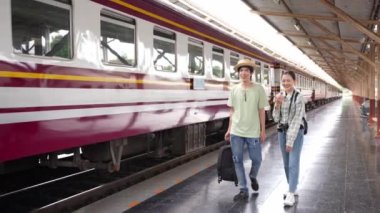 İki erkek ve kadın turist, turizm için trenle seyahat etmeye hazırlanıyor. 4K yavaş çekim videosu.