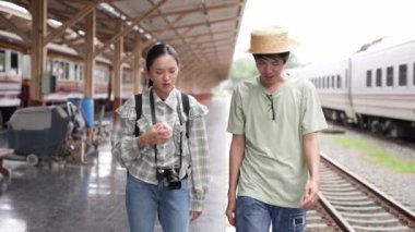 İki erkek ve kadın turist, turizm için trenle seyahat etmeye hazırlanıyor. 4K yavaş çekim videosu.