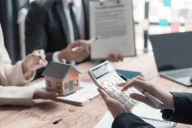 İş adamları gayrimenkul hakkında konuşmak için toplanıyor. Emlak işinde takım çalışması. Müşterilere tanıtmak için satış yaklaşımı analiz ediliyor. Yakın plan..