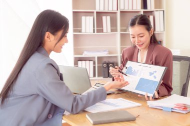 İki profesyonel iş kadını mali rapor, iş planı, yatırım ve mali analizi analiz ediyor..