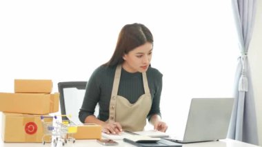 Fatura kutuları üzerinde çalışan ve kutuları hazırlamak, müşterilere satmak için online siparişleri kontrol eden kadın KOBİ işletme sahibi girişimci. Çevrimiçi KOBİ iş konsepti, küçük işletme başlangıcı.