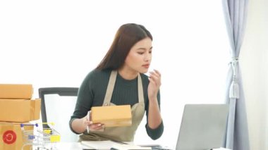 Fatura kutuları üzerinde çalışan ve kutuları hazırlamak, müşterilere satmak için online siparişleri kontrol eden kadın KOBİ işletme sahibi girişimci. Çevrimiçi KOBİ iş konsepti, küçük işletme başlangıcı.