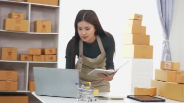 Fatura kutuları üzerinde çalışan ve kutuları hazırlamak, müşterilere satmak için online siparişleri kontrol eden kadın KOBİ işletme sahibi girişimci. Çevrimiçi KOBİ iş konsepti, küçük işletme başlangıcı.