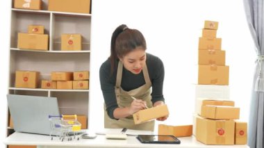 Fatura kutuları üzerinde çalışan ve kutuları hazırlamak, müşterilere satmak için online siparişleri kontrol eden kadın KOBİ işletme sahibi girişimci. Çevrimiçi KOBİ iş konsepti, küçük işletme başlangıcı.