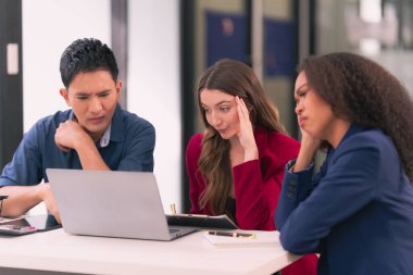 İş dünyası ekibi, kötü iş ekonomisinde yorgun ve stresli görünen dizüstü bilgisayarı kullanarak ellerini kafaya koyarken hem stresli hem de stresli görünüyor.
