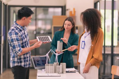 Konut geliştirme projesi mühendisi için yenilenebilir enerji çözümü konsepti Rüzgar türbini modeli üzerinde beyin fırtınası yapan inşaat konsepti ile dijital tablet üzerinde planlanan rüzgar türbini mühendisi