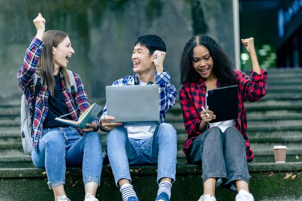 Bir grup Asyalı kız üniversite öğrencisi parkta birlikte konuşuyor ve çalışıyorlar..
