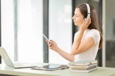 Güzel genç kadın iş için akıllı telefon kullanıyor İnternet üzerinden alışveriş, para transferleri, internet bankacılığı, dizüstü bilgisayarlar, uzaktan kumandalı işçiler, daktilo ile bir e-posta ya da araştırma gönder.