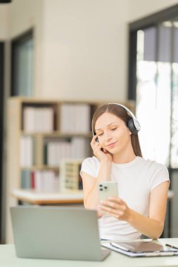 Güzel genç kadın iş için akıllı telefon kullanıyor İnternet üzerinden alışveriş, para transferleri, internet bankacılığı, dizüstü bilgisayarlar, uzaktan kumandalı işçiler, daktilo ile bir e-posta ya da araştırma gönder.