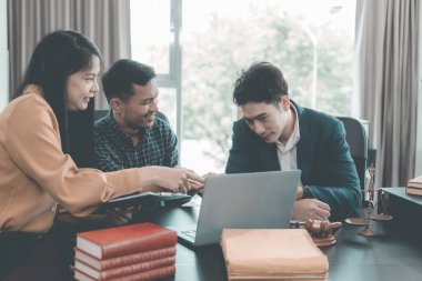 Avukatlar müşterilerle modern bir ofiste müşterilerle görüşür, müşterilerle görüşür. Avukatlar müşterilerine masalarında çalışırken aktif olarak danışmanlık yaparlar..