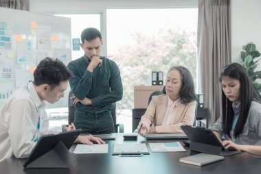 Ticari kavramları gösteren çizelge ve grafikleri tartışan bir grup iş adamı, yatırım ve iş büyümesi ile başarılı takım çalışması takım çalışması sonuçlarını gösteriyor.