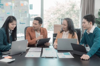 Ticari kavramları gösteren çizelge ve grafikleri tartışan bir grup iş adamı, yatırım ve iş büyümesi ile başarılı takım çalışması takım çalışması sonuçlarını gösteriyor.