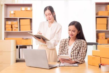 Küçük işletme girişimi, KME sahibi, çevrimiçi siparişleri kontrol eden Asyalı kadın, evde ürün satmak, kutular ve dizüstü bilgisayarlarla çalışmak, serbest çalışan