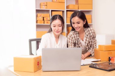 Küçük işletme girişimi, KME sahibi, çevrimiçi siparişleri kontrol eden Asyalı kadın, evde ürün satmak, kutular ve dizüstü bilgisayarlarla çalışmak, serbest çalışan