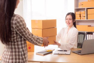 Küçük işletme girişimi, KME sahibi, çevrimiçi siparişleri kontrol eden Asyalı kadın, evde ürün satmak, kutular ve dizüstü bilgisayarlarla çalışmak, serbest çalışan