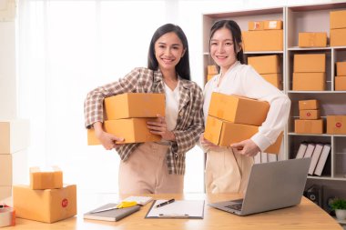 Küçük işletme girişimi, KME sahibi, çevrimiçi siparişleri kontrol eden Asyalı kadın, evde ürün satmak, kutular ve dizüstü bilgisayarlarla çalışmak, serbest çalışan