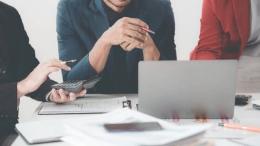 İş adamları başarılı takım çalışmalarını gösteren çizelge ve grafikleri tartışıyor. Ofisteki bir masada finansal verileri analiz eden bir iş arkadaşından oluşan bir ekibin yakın çekimi..