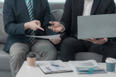 İş adamları başarılı takım çalışmalarını gösteren çizelge ve grafikleri tartışıyor. Ofisteki bir masada finansal verileri analiz eden bir iş arkadaşından oluşan bir ekibin yakın çekimi..