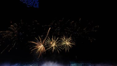 Şehrin üzerinde büyük havai fişekler, yeni yıl partisi arka planı, yeni yıl, koyu mavi gökyüzünde güzel renklerle uzun havai fişekler..