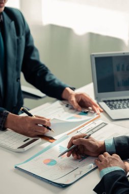 Dizüstü bilgisayarları ve mali grafik belgeleriyle birlikte veri analistlerinden oluşan bir ekip çevrimiçi incelemelerle pazar araştırma istatistiklerini işbirliği, yakın çekim, dikey
