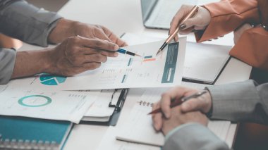 İş adamları veri şirketinin büyüme önerisinde başarılı takım çalışması gösteren grafikleri ve grafikleri tartışıyor. Analitik istatistik, bilgi grafikleri ve strateji fikirleri