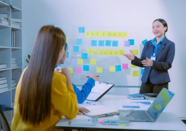 Asyalı iş kadınlarından oluşan bir grup başarılı takım çalışmalarını gösteren grafikler ve grafikler, şirket büyüme hedefleri, bilgisayar ekranlarındaki sunumlar hakkında görüştü.