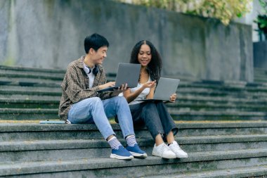 Bilgisayarlı eğitim kampüsü öğrencileri sınavlar, kitaplar, arkadaşlar ya da açık hava çeşitliliği hakkında konuşuyor ya da konuşuyor.