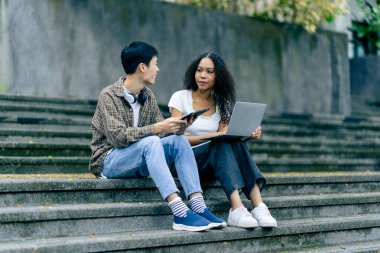 Bilgisayarlı eğitim kampüsü öğrencileri sınavlar, kitaplar, arkadaşlar ya da açık hava çeşitliliği hakkında konuşuyor ya da konuşuyor.