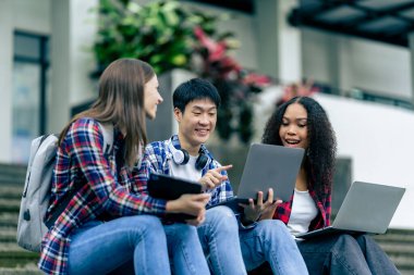 Bilgisayarlı eğitim kampüsü öğrencileri sınavlar, kitaplar, arkadaşlar ya da açık hava çeşitliliği hakkında konuşuyor ya da konuşuyor.