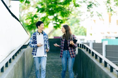 Bilgisayarlı eğitim kampüsü öğrencileri sınavlar, kitaplar, arkadaşlar ya da açık hava çeşitliliği hakkında konuşuyor ya da konuşuyor.