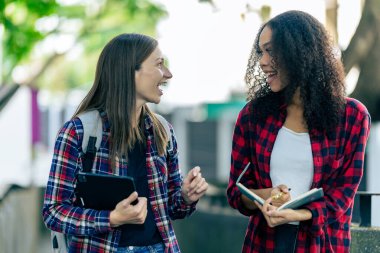 Bilgisayarlı eğitim kampüsü öğrencileri sınavlar, kitaplar, arkadaşlar ya da açık hava çeşitliliği hakkında konuşuyor ya da konuşuyor.
