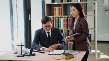 Avukatlar çekiç ve adalet terazisiyle büroda yasal belgeleri tartışıyorlar. Danışma ve hukuk kavramının buluşması, adaletin terazisiyle yargılama.