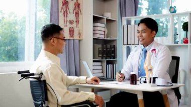 Yaşlı bir Asyalı, dizinde eklem maketi olan bir hastahanede diziyle ilgili fizyoterapiste danışıyor..