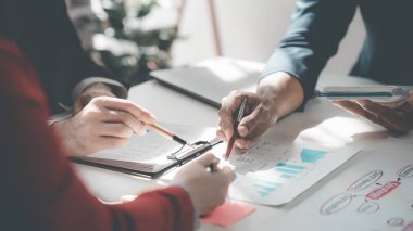 İş Meslektaşları ekibinin yakın plan görüntüleri modern ofisteki finansal verileri analiz ediyor iş stratejisi grupları başarılı takım çalışmalarını gösteren grafikler ve grafikleri tartışıyor..