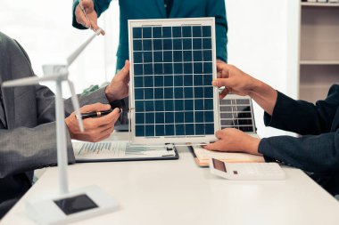 Alternatif enerji kavramı, elektrik mühendisi ve iş adamı çatıdaki yeni güneş paneli kurulum projesini tartışıyor. Yakın plan resimler.