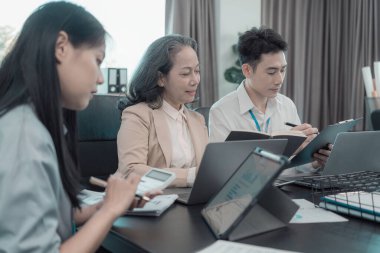 Bir grup iş arkadaşı konferans odasında çok yönlü modern ofiste toplanıyor: yöneticilerle yapılan iş toplantıları, konuşmalar, grafik sunumları, büyük veri dijital girişimcileri