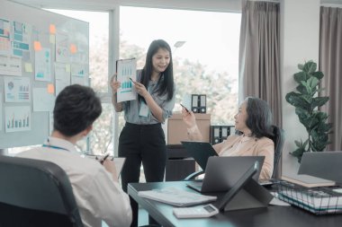 Bir grup iş arkadaşı konferans odasında çok yönlü modern ofiste toplanıyor: yöneticilerle yapılan iş toplantıları, konuşmalar, grafik sunumları, büyük veri dijital girişimcileri