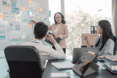 Bir grup iş arkadaşı konferans odasında çok yönlü modern ofiste toplanıyor: yöneticilerle yapılan iş toplantıları, konuşmalar, grafik sunumları, büyük veri dijital girişimcileri