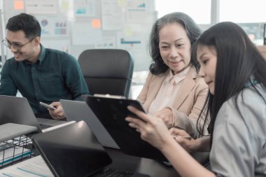 Bir grup iş arkadaşı konferans odasında çok yönlü modern ofiste toplanıyor: yöneticilerle yapılan iş toplantıları, konuşmalar, grafik sunumları, büyük veri dijital girişimcileri