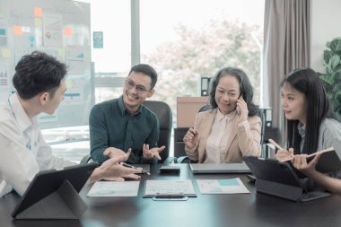 Bir grup iş arkadaşı konferans odasında çok yönlü modern ofiste toplanıyor: yöneticilerle yapılan iş toplantıları, konuşmalar, grafik sunumları, büyük veri dijital girişimcileri