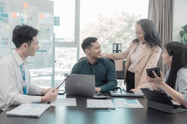 Bir grup iş arkadaşı konferans odasında çok yönlü modern ofiste toplanıyor: yöneticilerle yapılan iş toplantıları, konuşmalar, grafik sunumları, büyük veri dijital girişimcileri