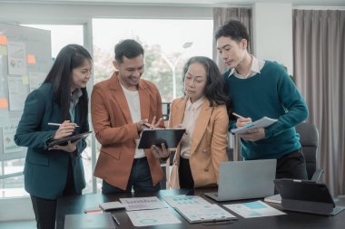 Bir grup iş arkadaşı konferans odasında çok yönlü modern ofiste toplanıyor: yöneticilerle yapılan iş toplantıları, konuşmalar, grafik sunumları, büyük veri dijital girişimcileri