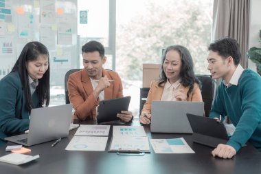 Bir grup iş arkadaşı konferans odasında çok yönlü modern ofiste toplanıyor: yöneticilerle yapılan iş toplantıları, konuşmalar, grafik sunumları, büyük veri dijital girişimcileri