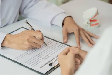 Kadın, dişçilik ve diş tedavisi konusunda doktora danışmanlık yapıyor. Yakın plan portre.