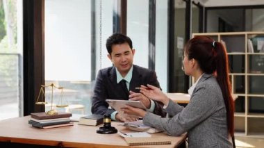 İki erkek ve kadın avukat müvekkil ile sözleşmeyi tartışıyorlar. Belgeleri gözden geçiriyorlar ve yasal adalet için müzakere koşulları sunuyorlar..